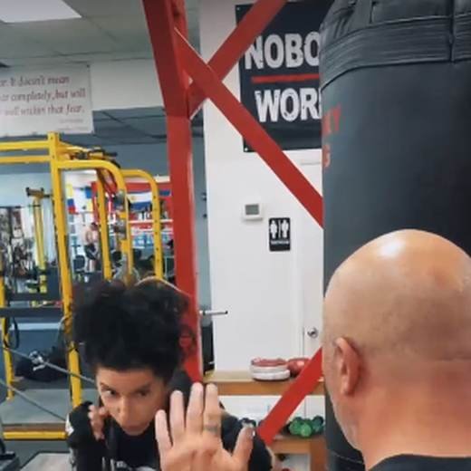 Adult member working the heavy bag on the gym floor at Kaminsky Boxing