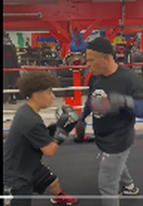 Coach working the mitts with a young boxer inside the ring at Kaminsky Boxing in Tarzana